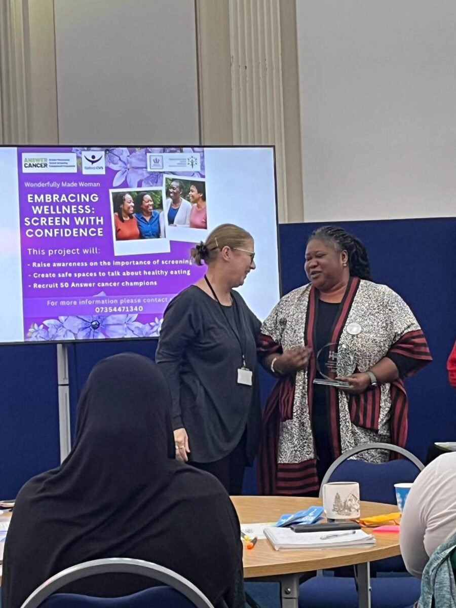 Award presentation in front of the Embracing Wellness: Screen with Confidence project slide