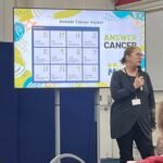 Speaker presenting the impact of the Answer Cancer programme at the Answer Cancer Champion Award Ceremony