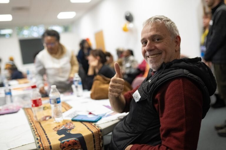 A guest smiling during the Honouring Our Communities celebration