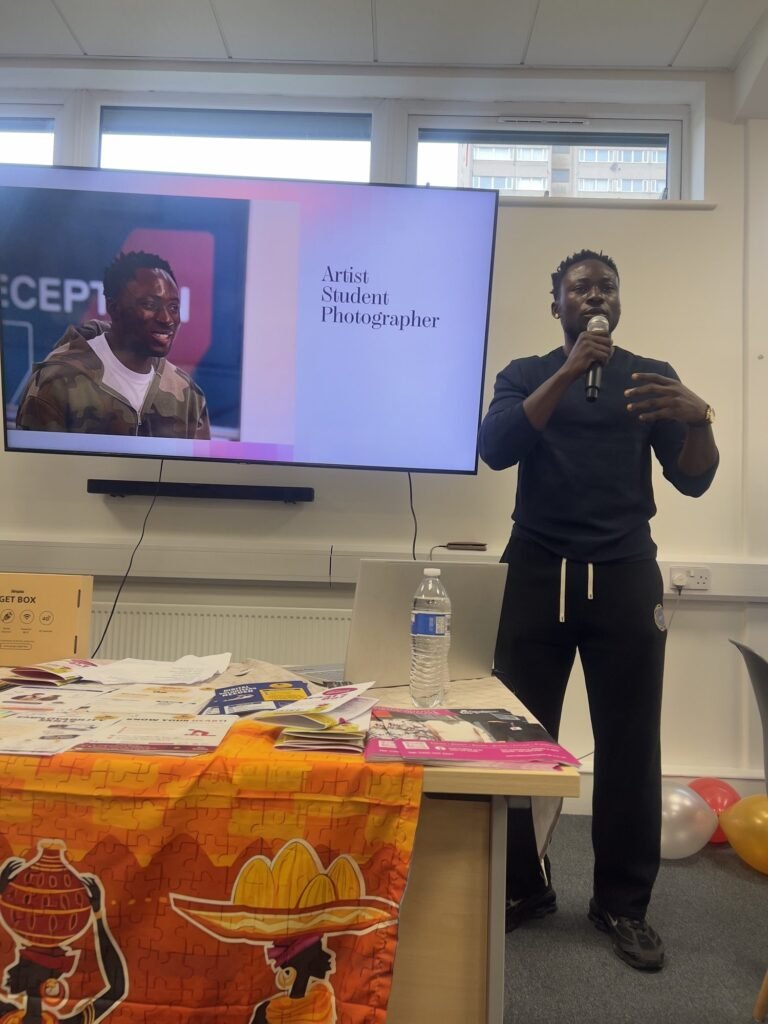A guest speaker with a microphone in front of a screen