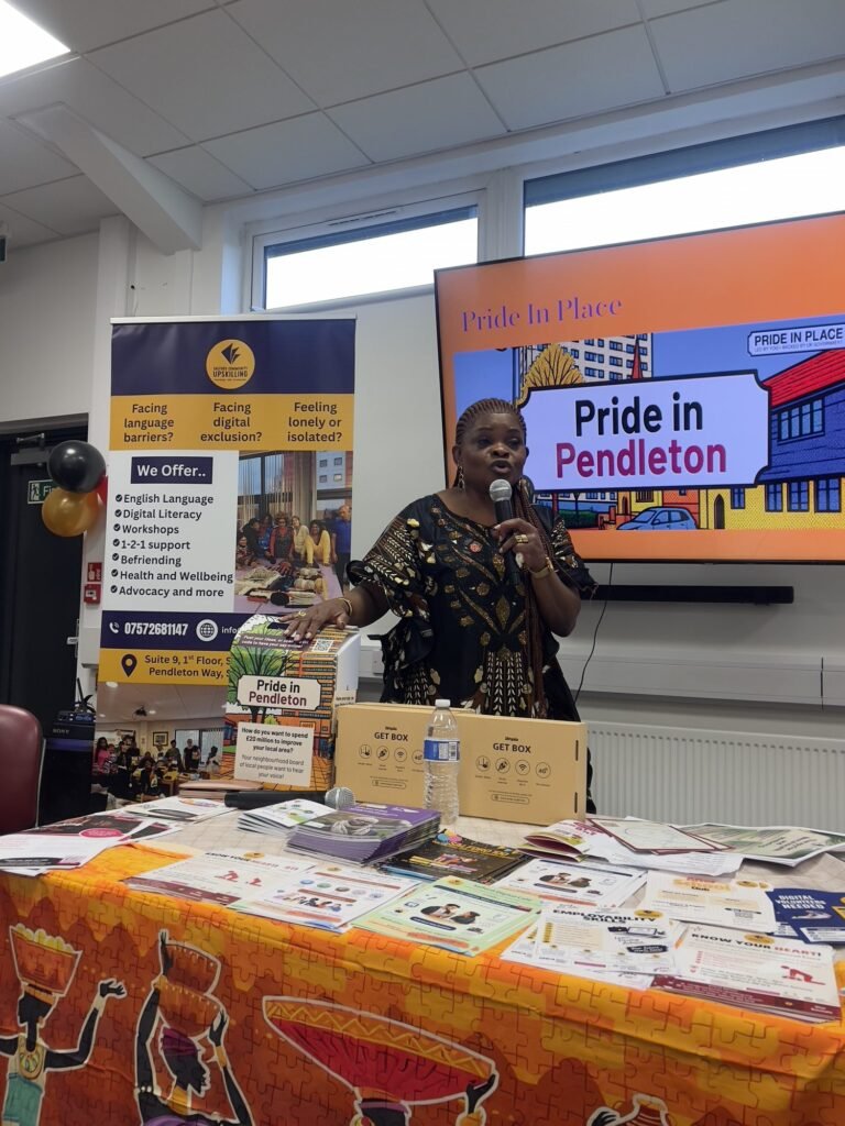A speaker beside a Pride in Pendleton display